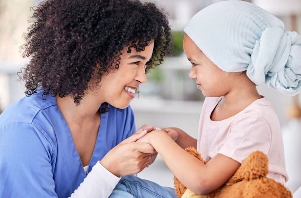 nurse holding hands with a cancer patient girl.