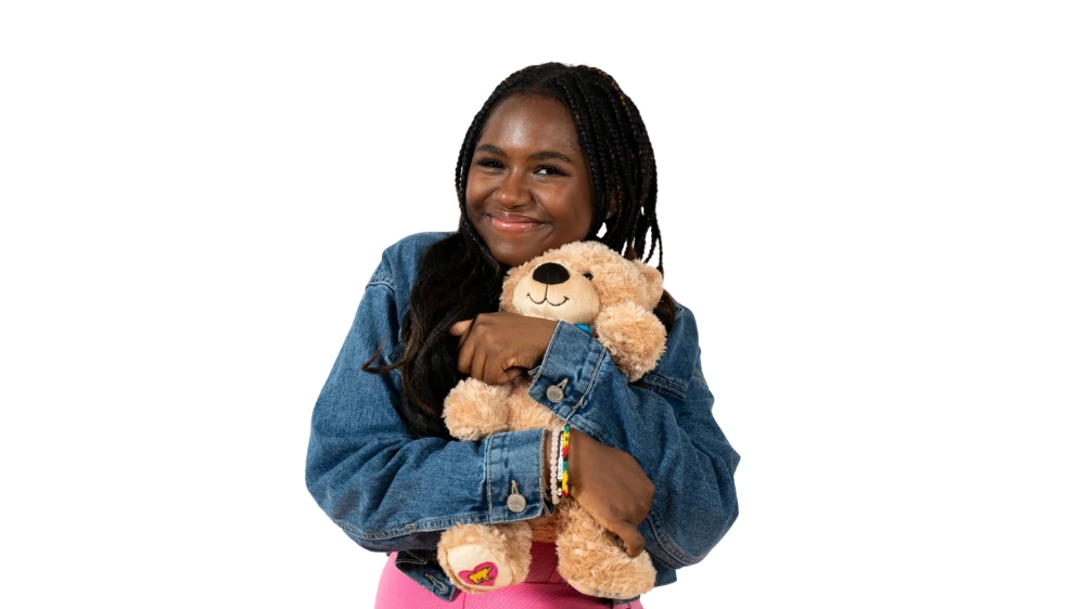 teenage girl hugging a teddy bear.