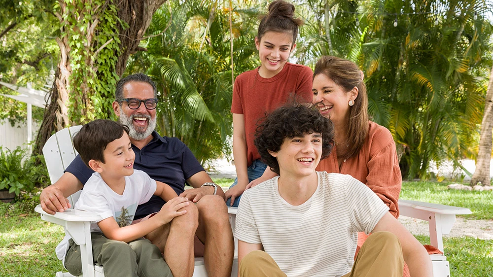 family of 5 relaxing in backyard garden.