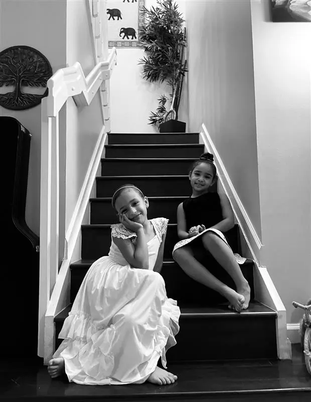 Patients Liv and Eva sitting on the stairs smiling.