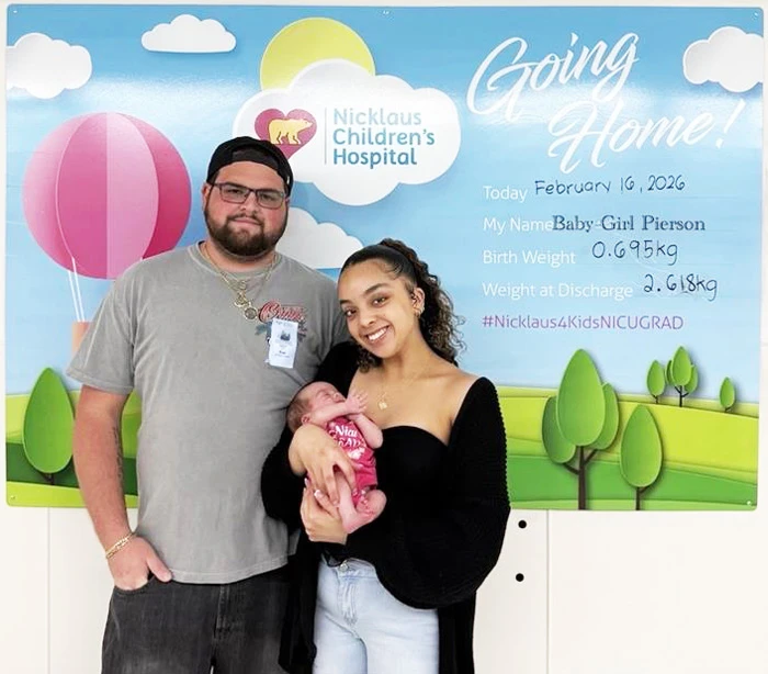 the tiny baby pierson held by her mother and father on the day of hospital discharge.