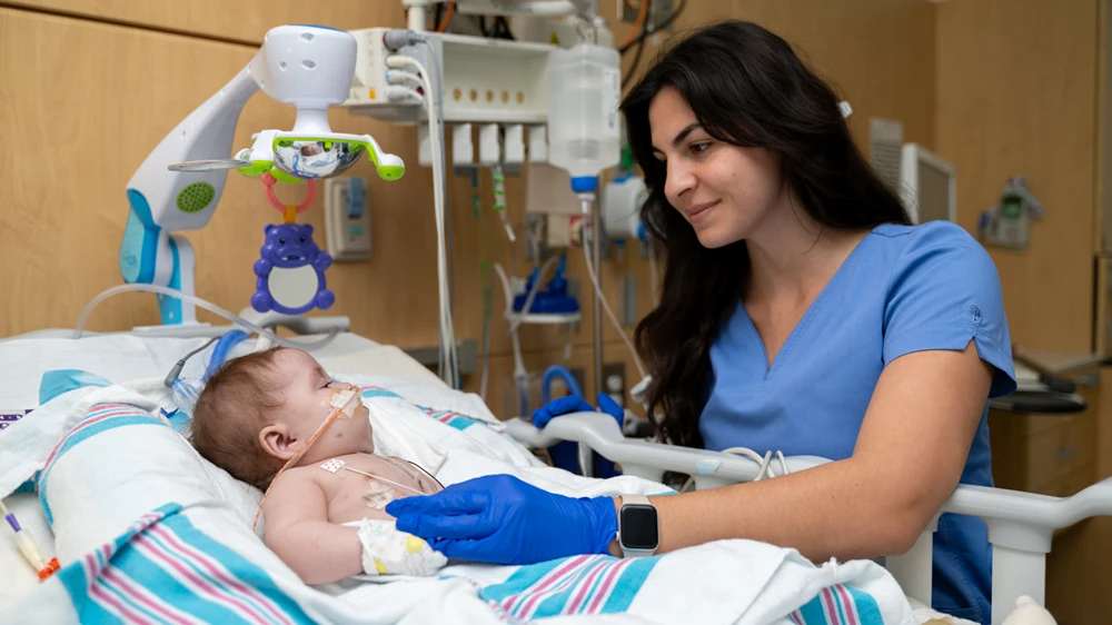 cardiac nurse attending to baby in critical care.
