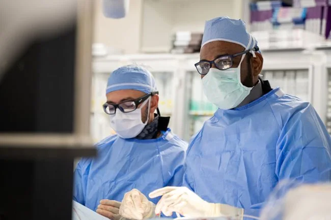 Dr. Sathanandam, chief of cardiovascular medicine and co-director of the Heart Institute wearing blue scrubs during an operation.