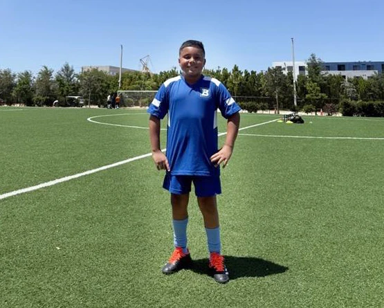 ignacio sonriente en un campo de fútbol de verano.