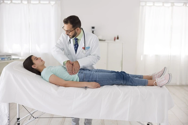 Teen female patient being examined by Gastroenterologist.
