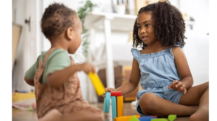 two children playing with colored wooden blocks.