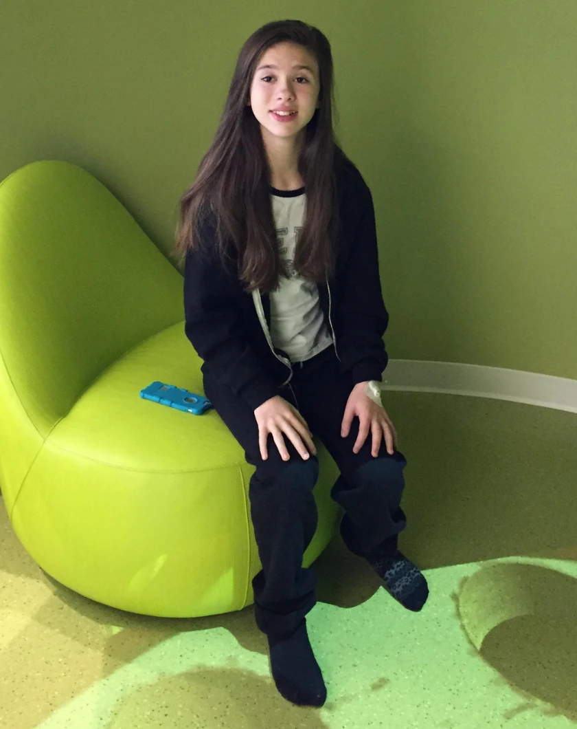Madison smiling on a green couch