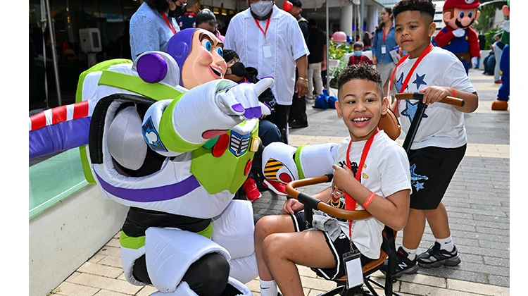 boy smiling with buzz lightyear costumed character.