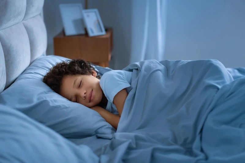 boy with curly hair sleeping.