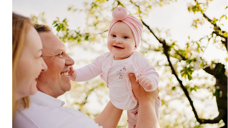 parents holding up their smiling baby girl.