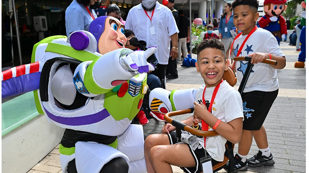 boy smiling with buzz lightyear costumed character.