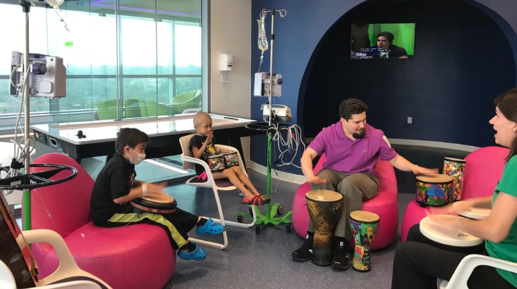 music therapists play the drums with patients and family.