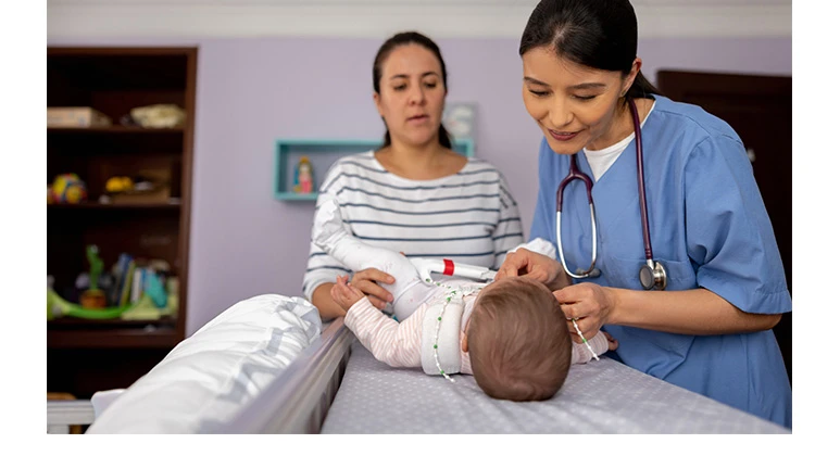 orthopedic nurse placing a hip brace on baby.